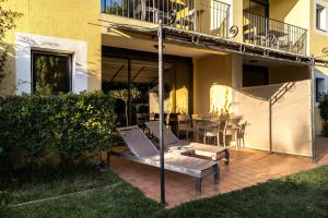 a patio with a table and chairs and a balcony at La Résidence du Bailli in Rayol-Canadel-sur-Mer