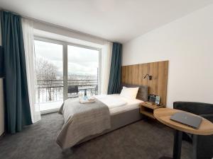 a bedroom with a bed and a desk and a window at Solina Resort in Polańczyk