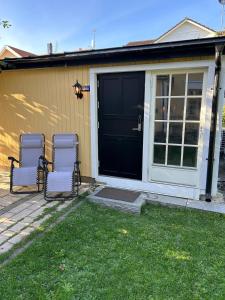 three chairs sitting in front of a black door at Citystugan in Västerås +1 photo