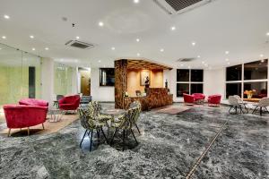 una hall con sedie rosse e un tavolo in una stanza di Tiaraa Jujurana Resort & Spa a Dharamsala