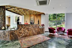 una hall con bancone in marmo e sedie rosse di Tiaraa Jujurana Resort & Spa a Dharamsala Altre 35 foto