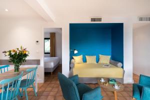 a room with a bed and a table and chairs at La Résidence du Bailli in Rayol-Canadel-sur-Mer