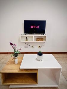 a white table with a tv on a wall at Amoblado Temporal M&S 3 L in Neuquén