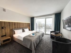 a hotel room with a bed and a window at Solina Resort in Polańczyk
