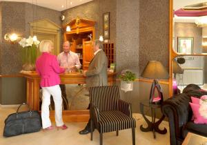 Un homme et une femme debout au comptoir dans l'établissement Hotel Figaro, à Knokke-Heist