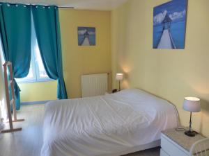 a bedroom with a white bed and two windows at Logis Hôtel Au Croissant in Buzançais