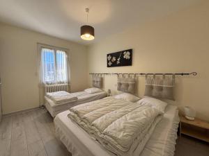 a bedroom with two beds and a window at Maison confortable à Villard-de-Lans - 8 couchages, WiFi, parking gratuit, proche des pistes et du centre. - FR-1-548-5 in Villard-de-Lans