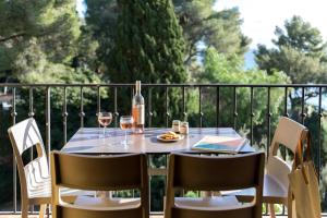 a table with a bottle of wine and two glasses at La Résidence du Bailli in Rayol-Canadel-sur-Mer