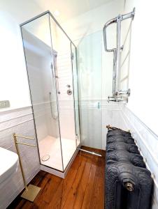 La salle de bains est pourvue d'une douche en verre avec un banc. dans l'établissement Hbhall Duomo Suite, à Milan 18 autres photos