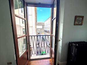 une porte ouverte s'ouvrant sur un balcon offrant une vue sur la ville. dans l'établissement Hbhall Duomo Suite, à Milan