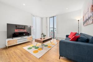 a living room with a blue couch and a tv at Modern Highrise Luxury Apartment in Manchester