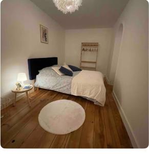 a bedroom with a bed and a table and a rug at Le nid du dernier sou in Boulogne-sur-Mer