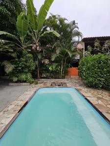 a blue swimming pool in a yard with palm trees at Hospedaria do Engenho in Niterói +61 photos