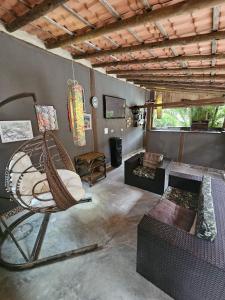 a living room with a rattan chair and a couch at Hospedaria do Engenho in Niterói