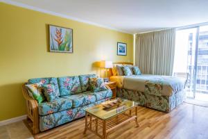 a living room with a couch and a bed at Tropical Studios at Marine Surf Waikiki - FREE PARKING - BEST LOCATION - FULL KITCHEN - SWIMMING POOL in Honolulu