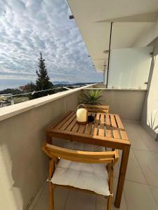 a wooden table and chair on a balcony at Dela in Hvar