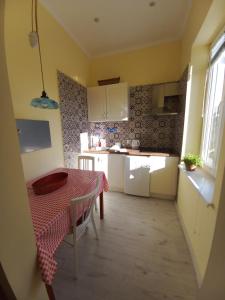 a kitchen with a table with a red and white checkered table cloth at Ergzotic Apartments & Room in Sombor