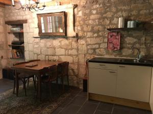a kitchen with a wooden table and a sink at Le Refuge des Châteaux in Chinon +9 photos