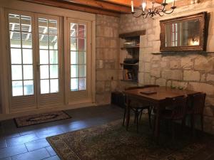 a dining room with a table and a stone wall at Le Refuge des Châteaux in Chinon