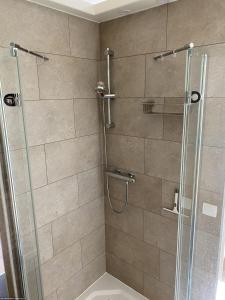 a bathroom with a shower with a glass door at Le Refuge des Châteaux in Chinon