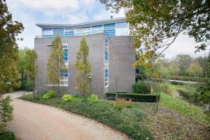 a building with a dirt road in front of it at DSW18 Luxury apartment in the centre with beach cabin in Domburg