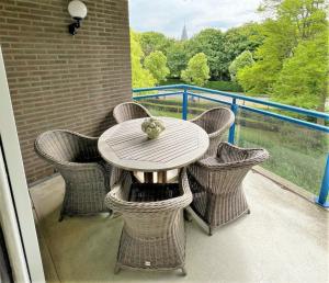 a table and chairs on a balcony with a view at DSW18 Luxury apartment in the centre with beach cabin in Domburg