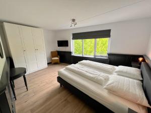 a bedroom with a large bed and a window at DSW18 Luxury apartment in the centre with beach cabin in Domburg