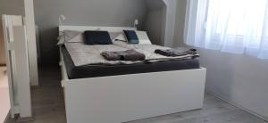 a bed in a room with a white bed frame at Bathy Ház in Tiszakécske