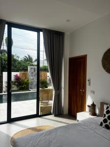 een slaapkamer met een bed en een glazen schuifdeur bij The Brova villa- Beautiful Private 3 bedroom villa in Nathon Bay +52 foto's