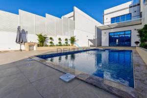 a swimming pool in front of a building at Special Rate with Temp Controlled Pool, BBQ & Maid's by Deluxe Holiday Homes in Fujairah