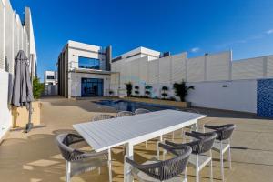 a white table and chairs on a patio at Special Rate with Temp Controlled Pool, BBQ & Maid's by Deluxe Holiday Homes in Fujairah
