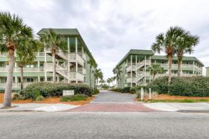 a street in front of two apartment buildings with palm trees at Pineapple Palms at the Sea Cabins in Isle of Palms