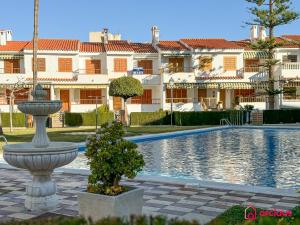 a fountain in front of a swimming pool with buildings at La Maison in Oropesa del Mar