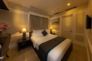a hotel room with a bed and a desk and lamps at Anpha Boutique Hotel in Ho Chi Minh City
