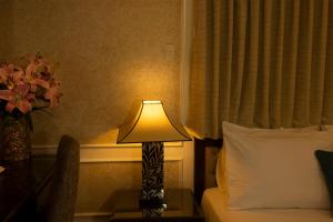 a lamp sitting on a table next to a bed at Anpha Boutique Hotel in Ho Chi Minh City
