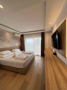 a bedroom with a large bed and a flat screen tv at Dela in Hvar