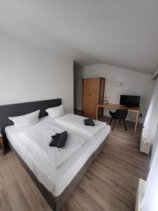 a bedroom with a large white bed and a desk at Appartement-Hotel Rostock in Rostock