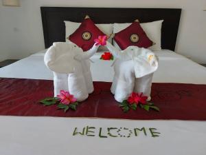 two stuffed elephants sitting on top of a bed at Monaburi Boutique Resort in Rawai Beach