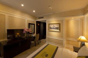 a hotel room with a bed and a desk and a television at Anpha Boutique Hotel in Ho Chi Minh City
