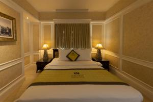 a bedroom with a large bed with two lamps at Anpha Boutique Hotel in Ho Chi Minh City