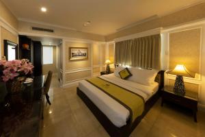 a bedroom with a bed with a desk and a window at Anpha Boutique Hotel in Ho Chi Minh City