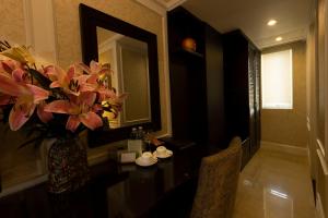 a vase of flowers on a table in a room at Anpha Boutique Hotel in Ho Chi Minh City
