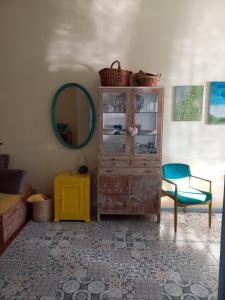 a room with a dresser and a mirror and a chair at Ergzotic Apartments & Room in Sombor
