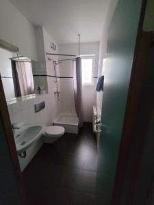 a bathroom with a toilet and a sink and a shower at Appartement-Hotel Rostock in Rostock