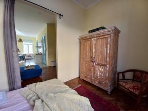 a bedroom with a large wooden cabinet and a bed at Ergzotic Apartments & Room in Sombor