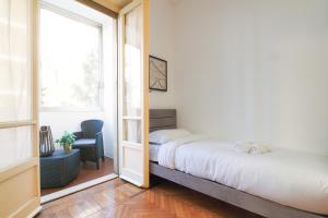 een kleine slaapkamer met een bed en een raam bij PrimoPiano - Cucchi in Milaan