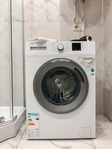 a white washing machine sitting in a bathroom at Apartments Domovik Mira 11s/9 in Mukacheve