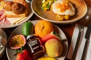 a table topped with plates of food with fruit and jam at The Click Clack Hotel Bogotá in Bogotá