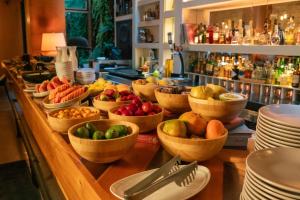 a buffet with bowls of fruits and vegetables on a counter at The Click Clack Hotel Bogotá in Bogotá