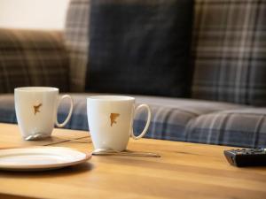 グリンデルワルトにあるApartment Chalet Abendrot apARTments-28 by Interhomeのテーブルと皿の上に座ったコーヒーカップ2杯 +27枚の写真
